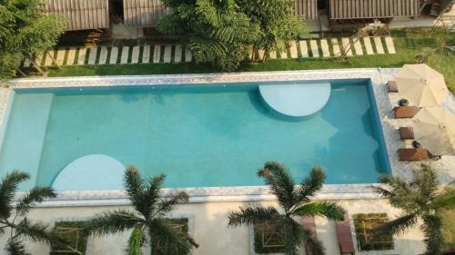 an overhead view of a swimming pool with palm trees at Remember Hotel in Ban Khouaphan