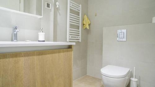 a white bathroom with a toilet and a sink at Allan's Home of Peace 2 in Viitasaari