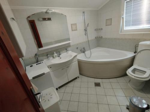 y baño con bañera, aseo y lavamanos. en Apartments Mali Dvori, en Srima