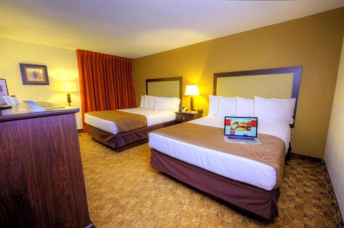a hotel room with two beds and a desk at Village Inn Clemmons-Winston Salem, Trademark by Wyndham in Clemmons