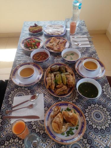 a table with plates of food on a table at Tasneem Palace in Luxor