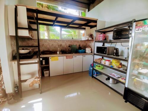 a kitchen with white cabinets and a refrigerator at Cozy73 Ocean View Villa Uluwatu in Uluwatu