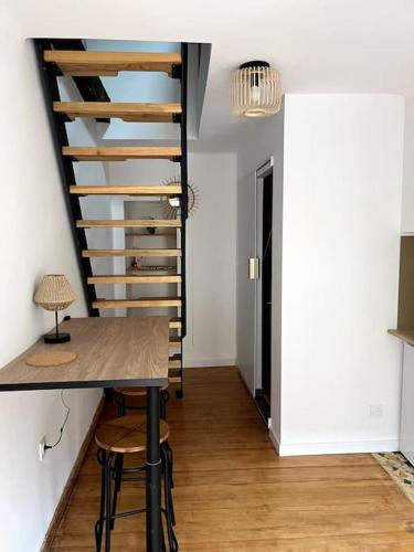 une salle à manger avec une table et un escalier en colimaçon dans l'établissement Maisonnette dans vieux village, à Espère