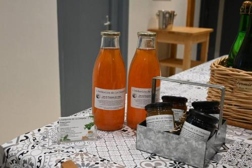 deux bouteilles de liquide orange posées sur une table dans l'établissement Normandy Holiday Home, à Barenton