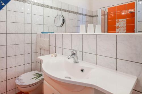 uma casa de banho com um lavatório e um WC em Haus Mertin Whg 2 Seewind em Heringsdorf
