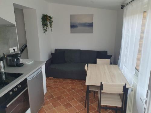 Il dispose d'une cuisine et d'un salon avec une table et un canapé. dans l'établissement Maison plain pied avec jardin, à Villeneuve-le-Roi