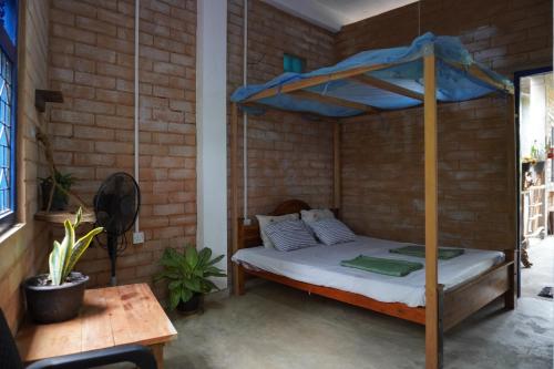a bedroom with a bed in a brick wall at PASSIONFRUIT HOMESTAY in Matara