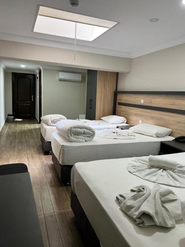 een hotelkamer met drie bedden en handdoeken erop bij Marka Hotel in Antalya