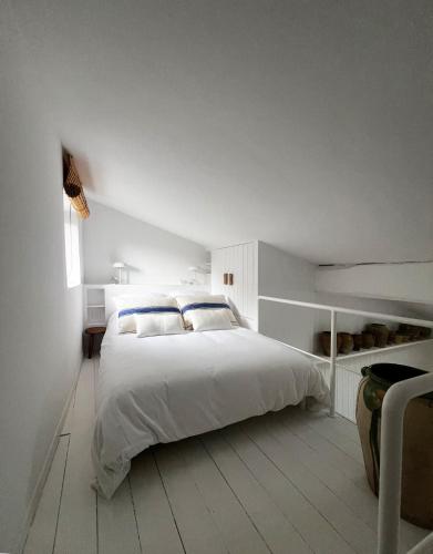 um quarto branco com uma grande cama branca e uma janela em Bergerie casitas suite em Canet-en-Roussillon