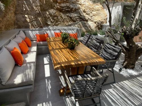 a wooden table and couch on a patio at Mykonian 4 Bd Ocean Dream House in Agios Sostis in Agios Sostis Mykonos