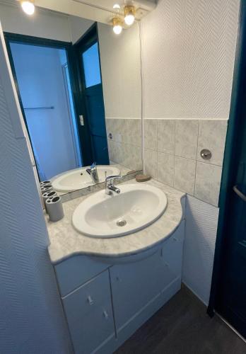 une salle de bain avec un lavabo et un miroir dans l'établissement Le Phare du Tréport - Vue Quai - Hyper Centre, au Tréport