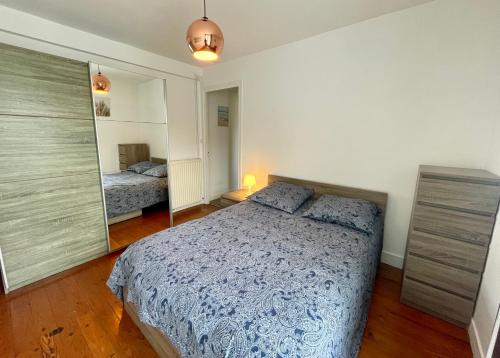 une chambre avec un lit avec une couette bleue dans l'établissement Le Phare du Tréport - Vue Quai - Hyper Centre, au Tréport