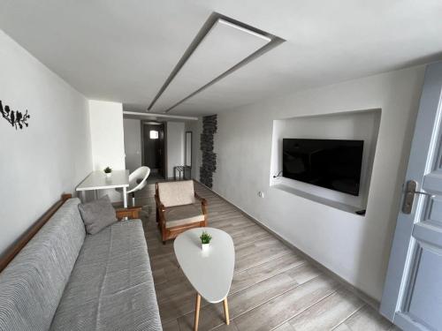un soggiorno con divano e TV di Emporio New Classic 1Bd Santorini Stylish Apt a Emporio