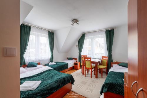 1 dormitorio con 2 camas, mesa y sillas en Kozinówka en Zawoja