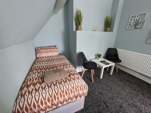 um quarto com uma cama, uma mesa e cadeiras em Airfield Manor em Castle Donington