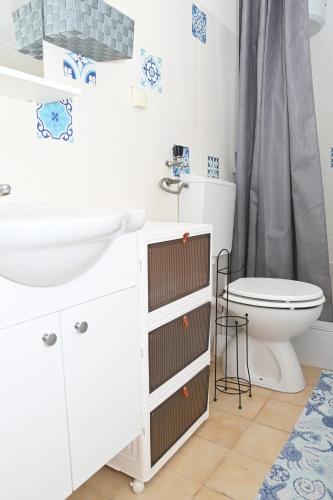 Baño blanco con lavabo y aseo en Apartment Oscar en Mokošica