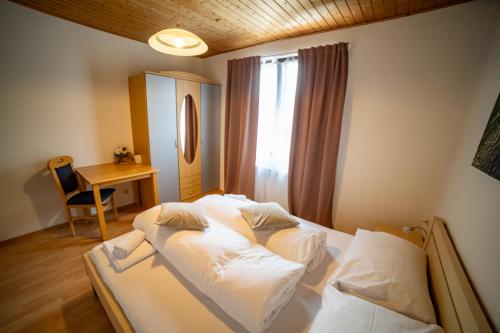 a bedroom with two beds and a desk and a window at Keutschacherhof in Keutschach am See