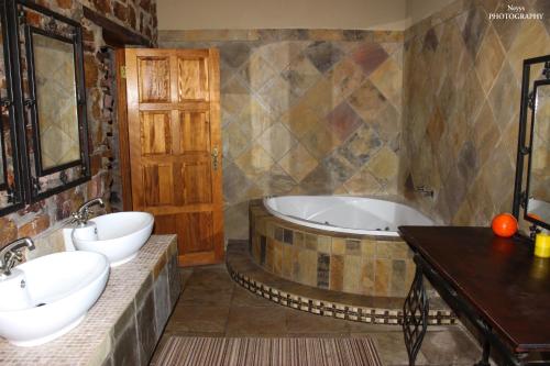 uma casa de banho com 2 lavatórios e uma banheira em Soloko Game farm em Kareedouw