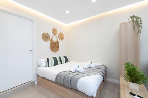 a white bedroom with a bed with white sheets and pillows at EXCLUSIVE APARTMENT JACUZZi in Málaga
