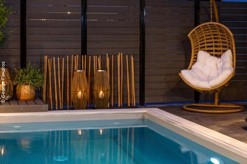 a chair next to a swimming pool with a chair and a chair at Villa Hendel Lefkada in Lygia