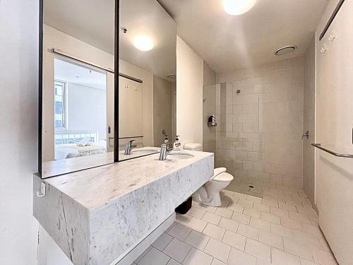 La salle de bains est pourvue d'un grand lavabo et de toilettes. dans l'établissement The Bell in Melbourne CBD 19A, à Melbourne