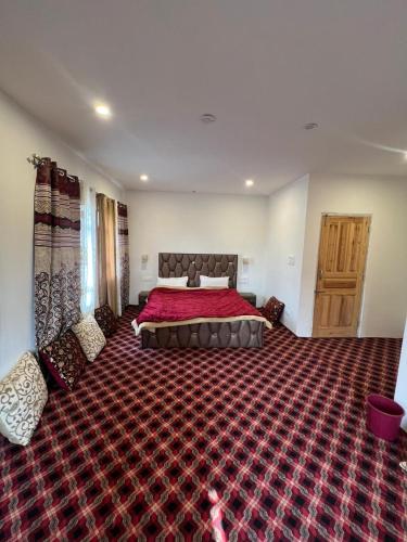 una grande camera da letto con un grande letto con una coperta rossa di Vale of Kashmir Homestay a Srinagar