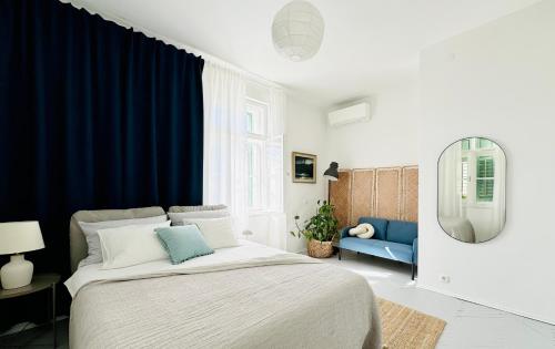 a bedroom with a large bed and blue curtains at Jardin Rooms in Split