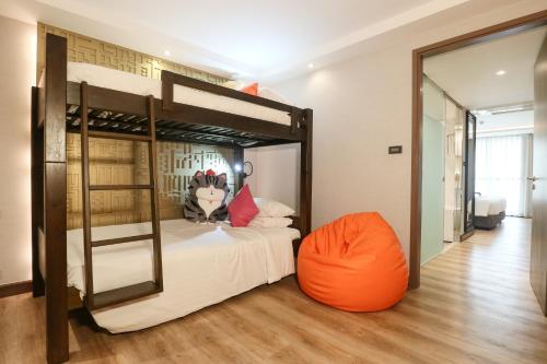 a bedroom with a bunk bed with an orange chair at Citrus Suites Sukhumvit 6 by Compass Hospitality in Bangkok