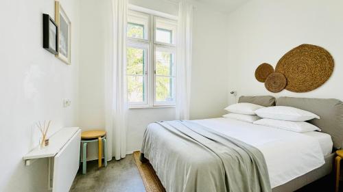 a white bedroom with a bed with white sheets and pillows at Jardin Rooms in Split