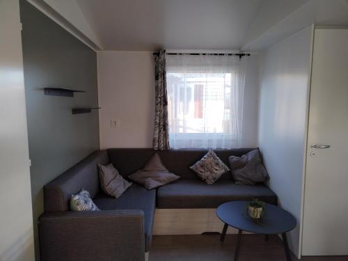 a living room with a couch and a window at Camping Le Lac des Rêves Lattes in Pérols