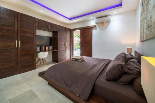 a bedroom with a large bed and a tv at Villa Minha Gente Seminyak in Seminyak