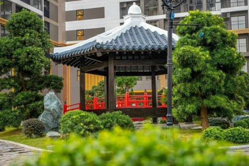 a gazebo with a red bridge in a city at Bunny Bliss-Service Apartment in Hanoi