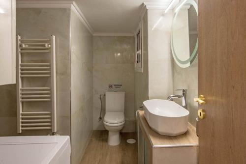 a bathroom with a white toilet and a sink at Iris luxury apartment in Athens