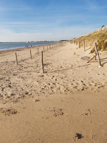a beach with a fence in the sand at Studio 2 à 4 personnes proche de la plage in La Guérinière
