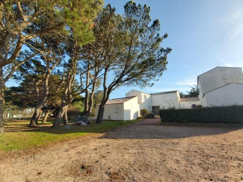 une maison avec des arbres et un chemin de terre dans l'établissement Studio 4 pers. bord de plage, à La Guérinière