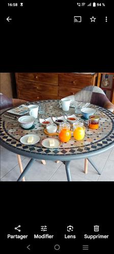 a table with bowls and plates on top of it at chambre d'hôte La Paisible in Treize-Vents