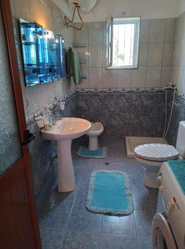 La salle de bains est pourvue d'un lavabo et de toilettes. dans l'établissement shtepi private 2 kateshe me parking, à Pogradec