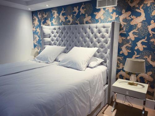 ein Schlafzimmer mit einem großen Bett mit blauer Wand in der Unterkunft Cannes, perfect holiday villa with heated pool in Le Cannet