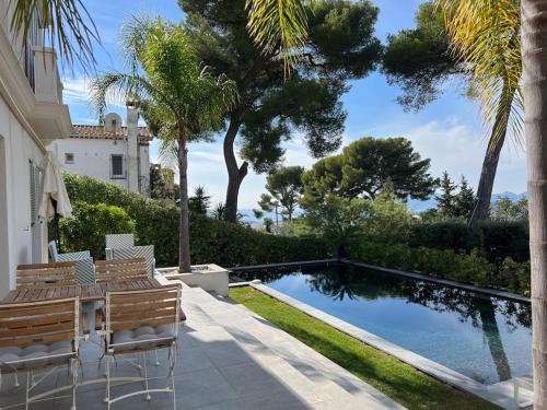 une maison avec une piscine et quelques palmiers dans l'établissement Villa Lion, gorgeous villa in Le Cannet overlooking Cannes, au Cannet