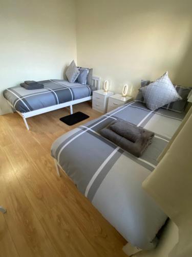 Duas camas num quarto com pisos em madeira em Spacious 3 Bed House in Penrhyn Bay Llandudno em Llandudno