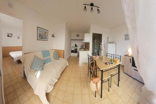 un salon avec un canapé et une table dans l'établissement Le Flamand Rose à 300 de la plage - 400m du centre ville, au Grau-du-Roi