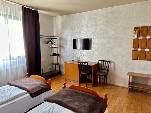 1 dormitorio con 2 camas, escritorio y mesa en Panoramic Cetatuie en Cluj-Napoca