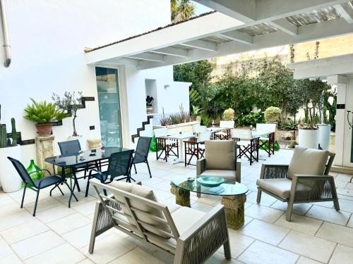 un patio esterno con tavoli, sedie e tavolo di Palazzo Cavour a Lecce