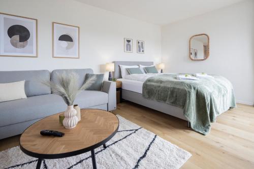 a living room with a bed and a coffee table at STAYY Sky Studio near Limmattal Hospital - contactless check-in in Schlieren