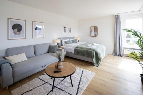 un soggiorno con un divano e un letto di STAYY Sky Studio near Limmattal Hospital - contactless check-in a Schlieren