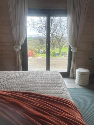 - une chambre avec un lit et une grande fenêtre dans l'établissement Un petit îlot de confort - made in Finland, à Monflanquin
