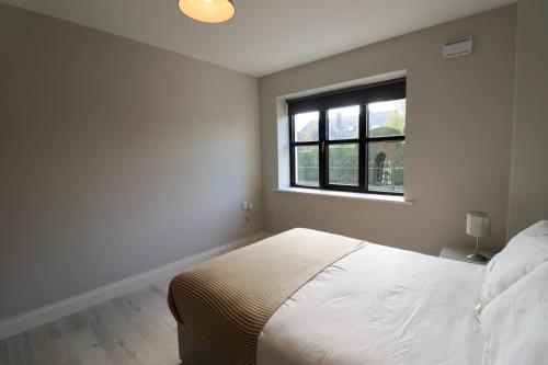 a white bedroom with a bed and a window at Inviting 2-Bed Apartment in Dublin in Dublin