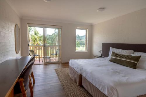 a bedroom with a large bed and a balcony at Wisemans Retreat in Wisemans Ferry