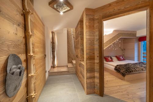 a bedroom with a bed in a room with wooden walls at Mas del Mezdì - mountain chalet Val di Rabbi in Rabbi