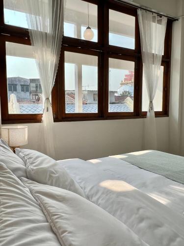 a bedroom with a bed and two windows at Sabay Home in Bangkok